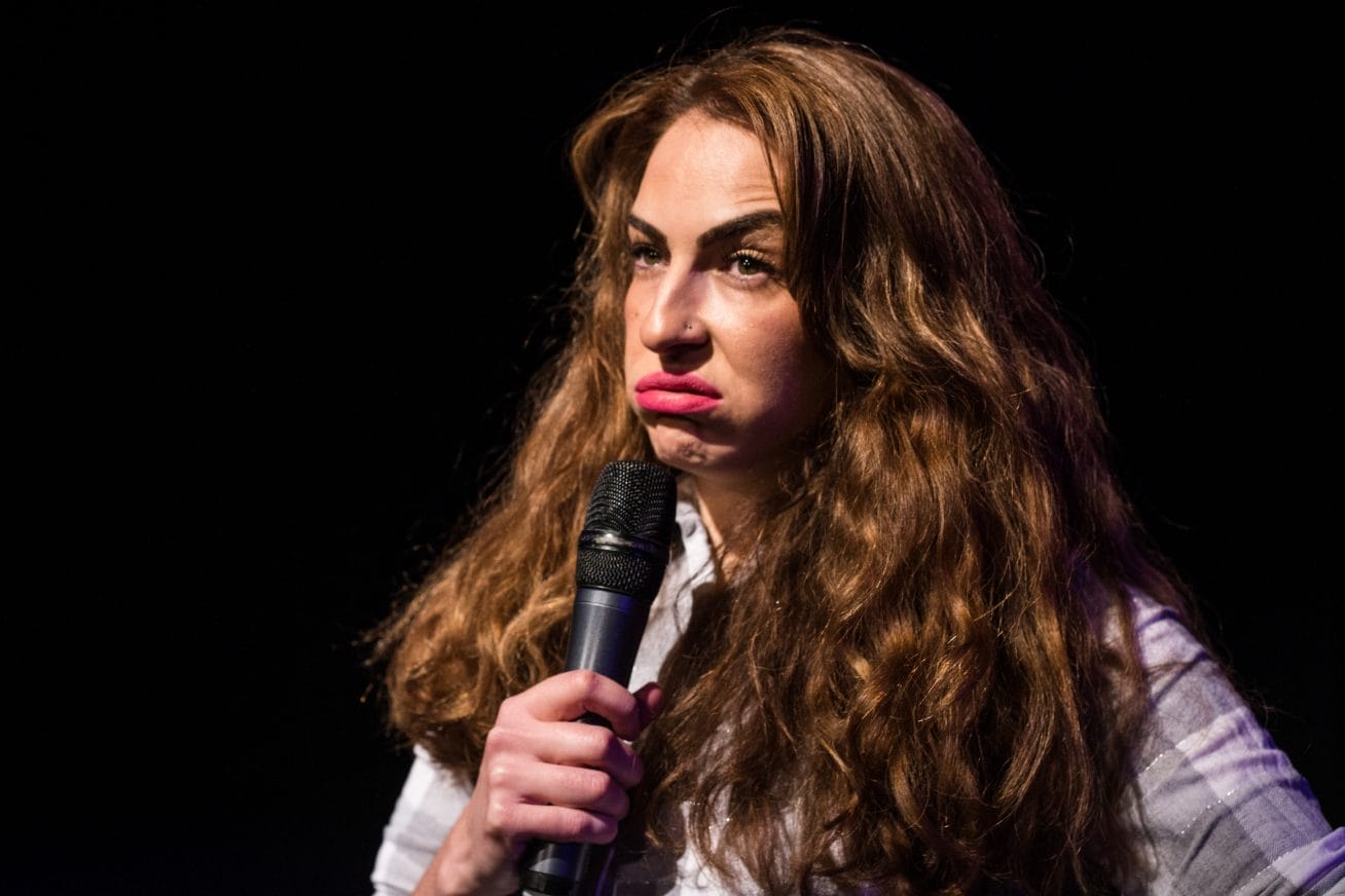 A woman holds a microphone looking fed up