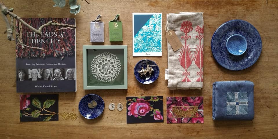 A selection of bowls, books and art are laid out on a table at a market