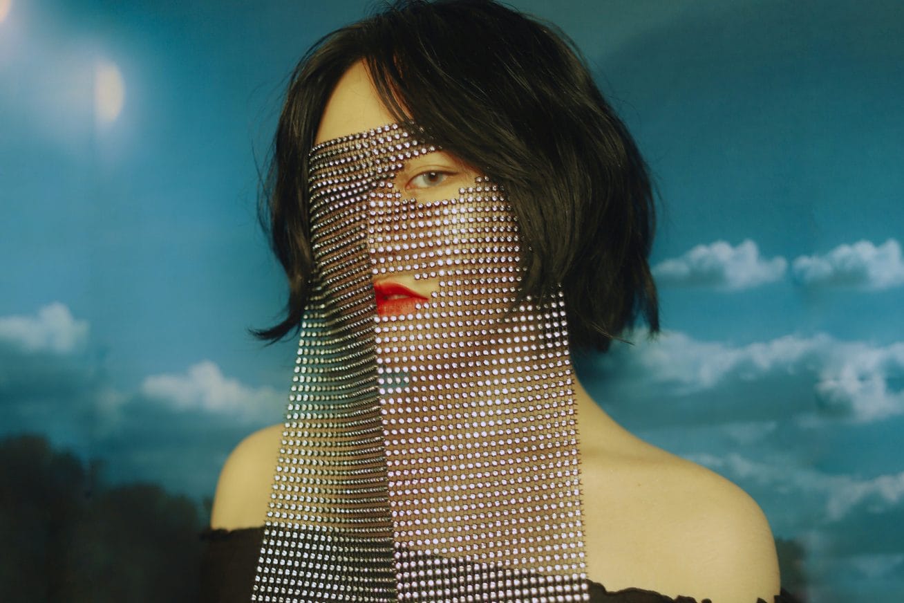 A woman poses with a mesh vail over her face