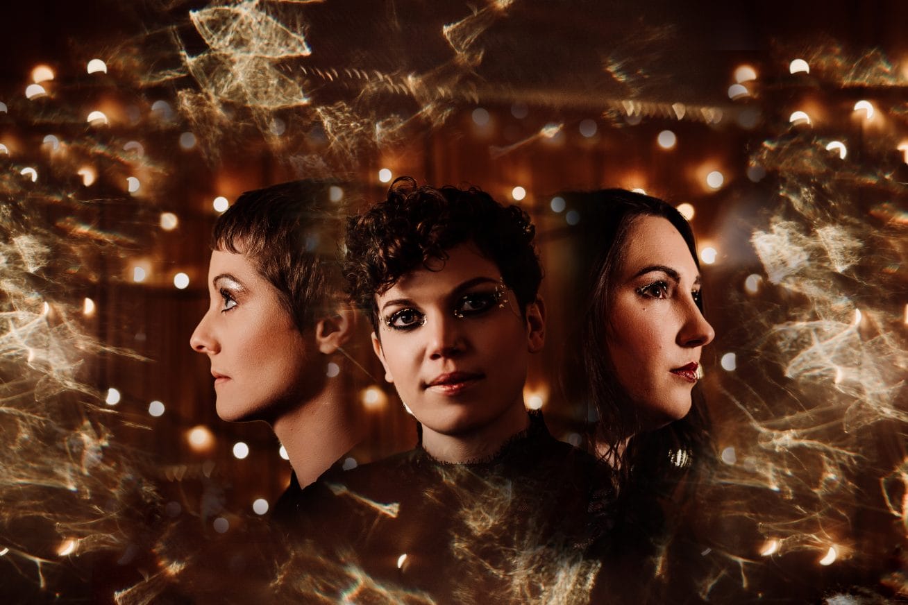 Three heads float amongst yellow/orange stars
