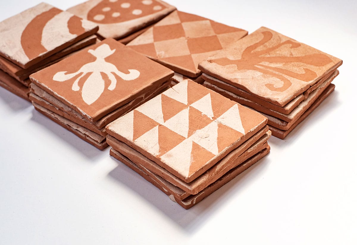 Terracotta style tiles with white patterns on them