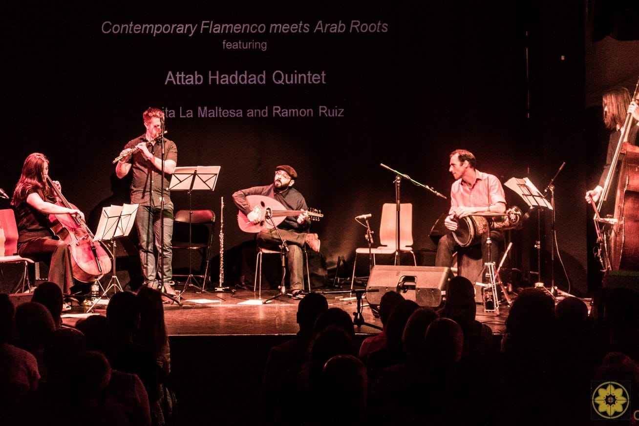 Several musicians play various instruments on a stage