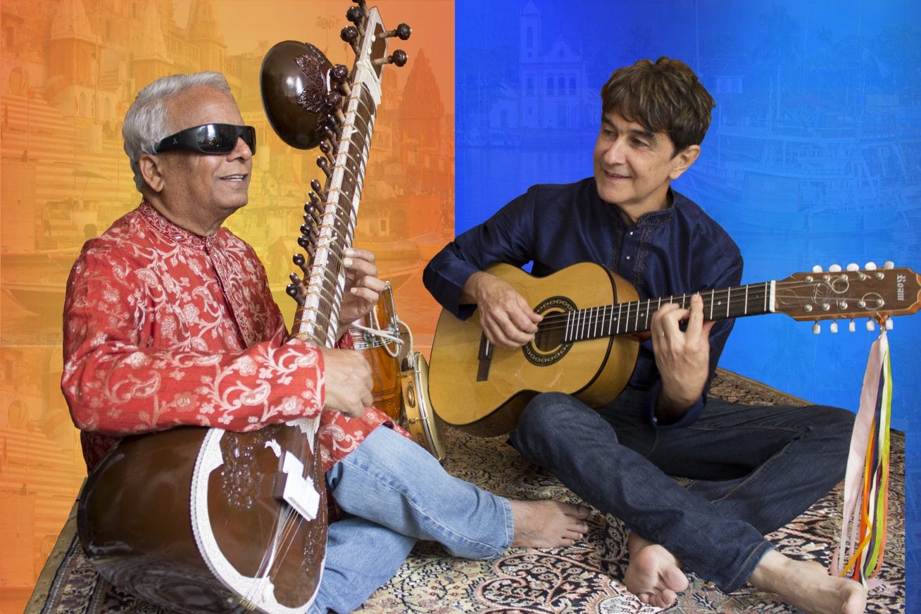 Two musicians - Gui Tavares and Baluji Shiravastav - play side by side on stage