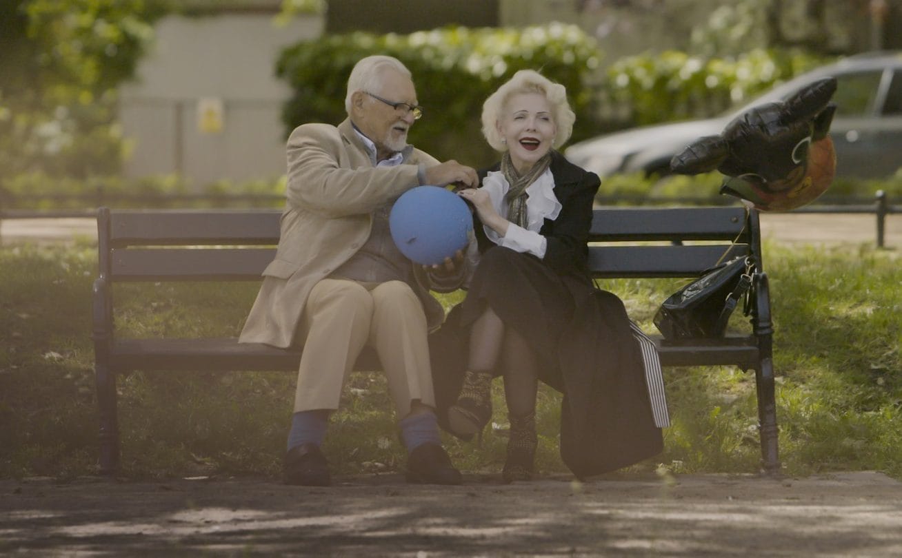 an older woman and a man playing with a balloon